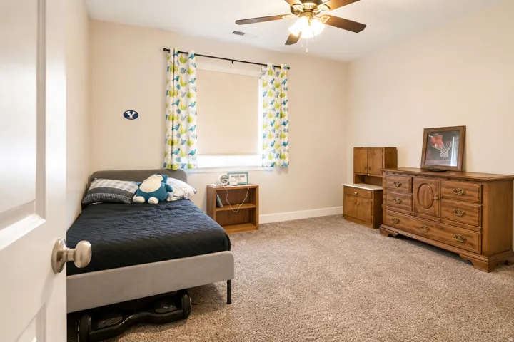 Wall-to-wall carpeting and a ceiling fan with integrated lighting