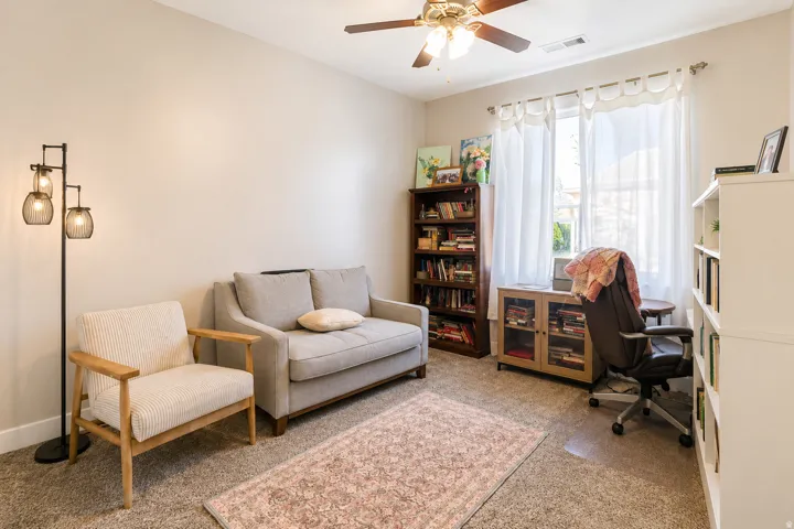 Recessed window with natural light, ceiling fan, neutral wall paint, and carpeted flooring