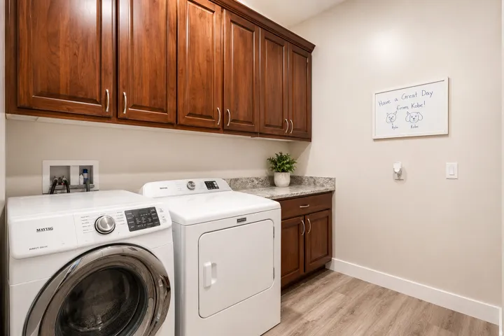 Wood-finish flooring, built-in upper cabinetry, built-in lower cabinetry, built-in countertop, and an integrated wall box for laundry hookups