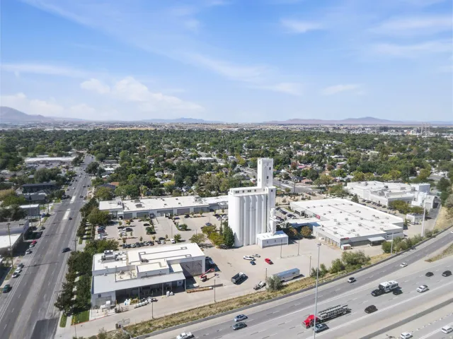 Expansive commercial property with multiple buildings, a prominent white silo structure, and direct access to a multi-lane highway