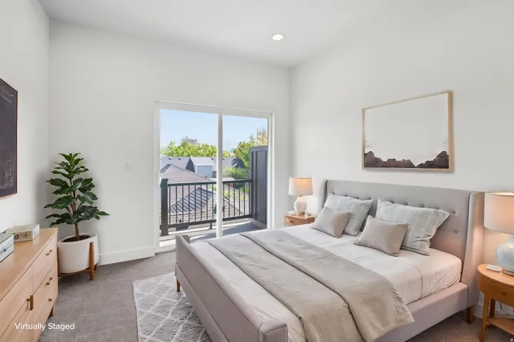 Recessed lighting, light-toned walls, and sliding glass doors opening to a balcony with black metal railings