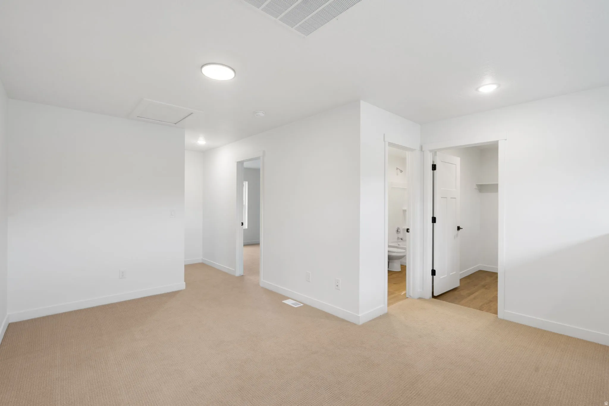 Plush carpet flooring, recessed lighting, white interior doors, and a neutral color palette