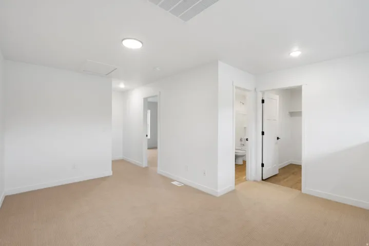 Plush carpet flooring, recessed lighting, white interior doors, and a neutral color palette