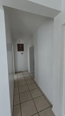 Hallway featuring light-toned square floor tiles