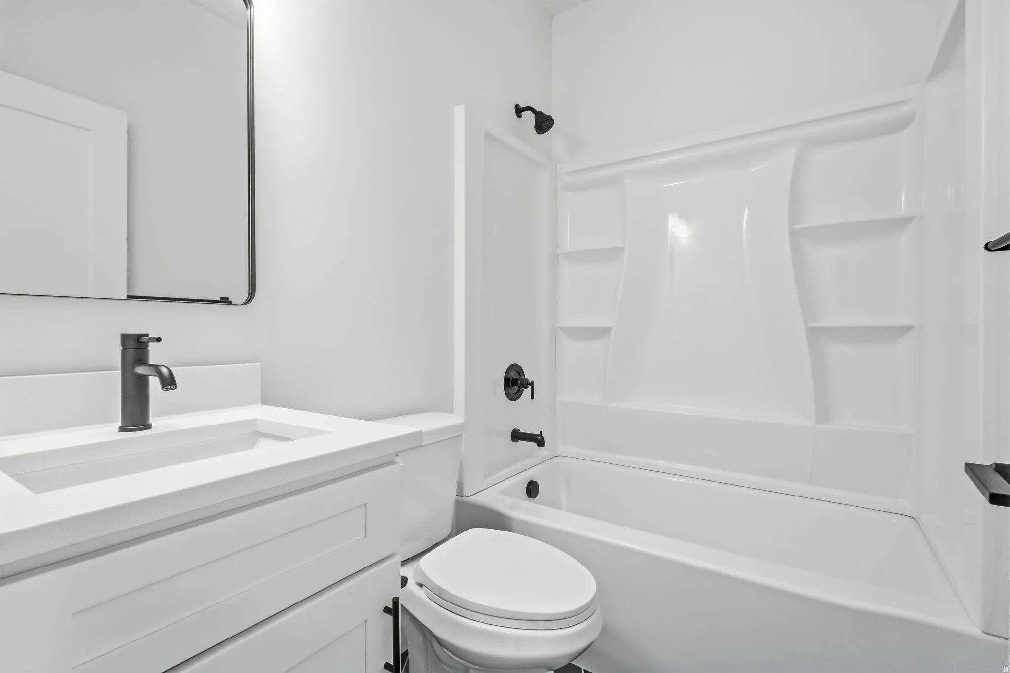 White vanity with a rectangular integrated sink and quartz countertop