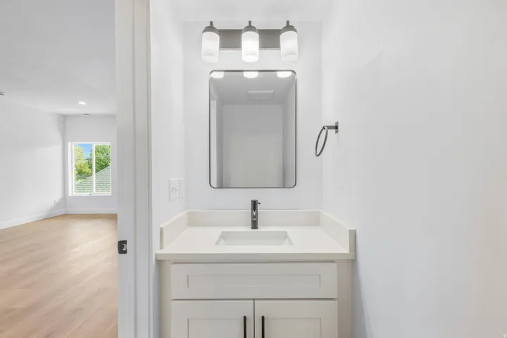 White vanity with a white countertop and rectangular sink
