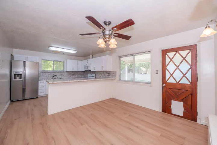 Kitchen with a breakfast bar, white cabinetry, and stainless steel appliances