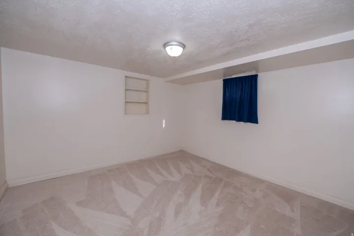 Recessed shelving unit, textured ceiling, flush-mount ceiling light fixture, wall-to-wall carpeting