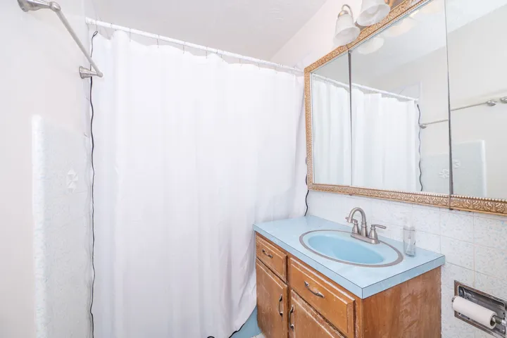 Wood-finish vanity with a blue countertop and integrated sink