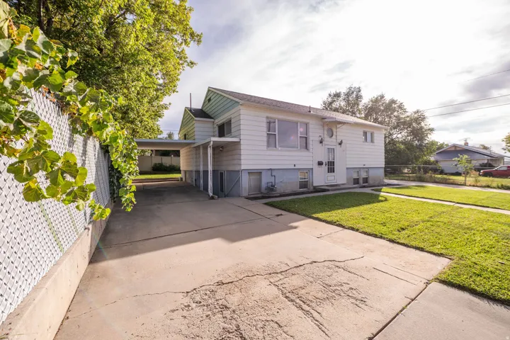 White exterior with blue trim accents and a concrete driveway