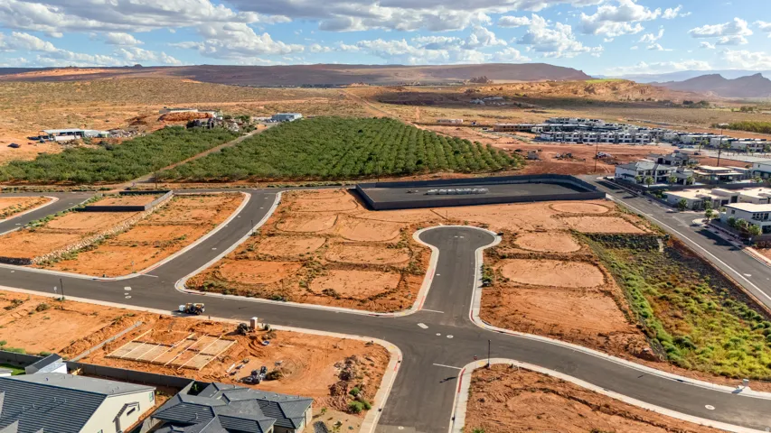 Expansive lot with potential for custom build, featuring an established road system, visible utilities, and mature desert landscaping