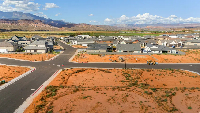 Expansive residential development with paved streets and surrounding mountain scenery