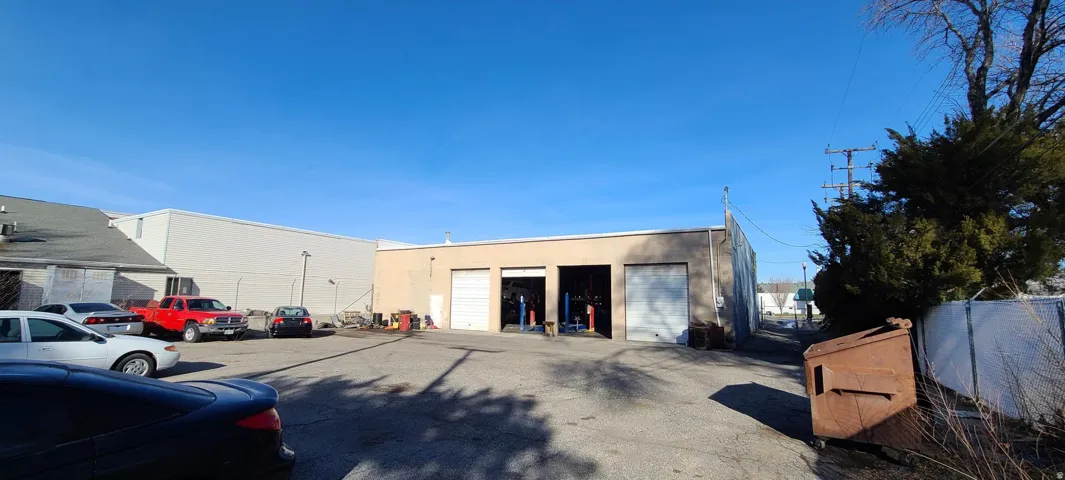 Commercial building featuring multiple roll-up doors and a paved lot