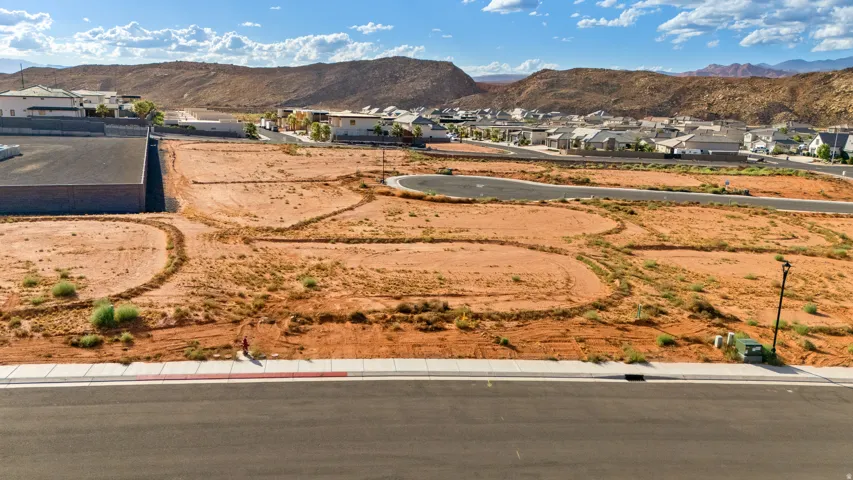 Expansive undeveloped land featuring paved roads and curb-and-gutter infrastructure