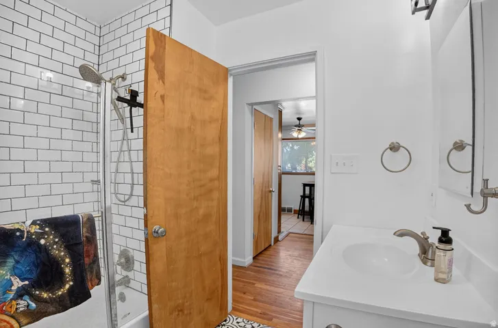 Shower with white subway tile surround, brushed nickel shower head, and clear glass enclosure