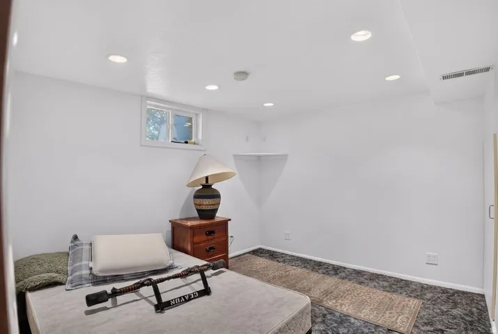 Recessed ceiling lighting, a corner niche, and a window with a white frame