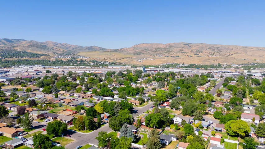 Residential area with mature trees and mountain backdrop