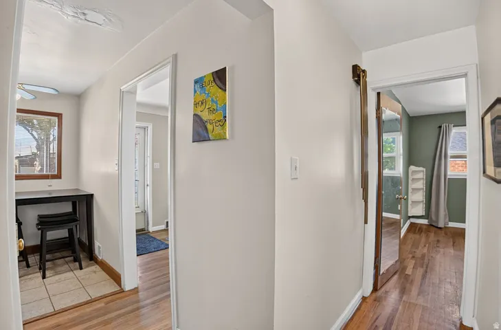 Wood-finish flooring throughout, light neutral wall colors, and a separate tiled entry area