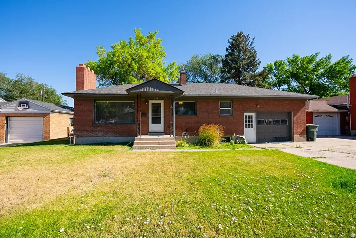 Brick exterior featuring a front entry, covered porch, attached garage, and detached garage