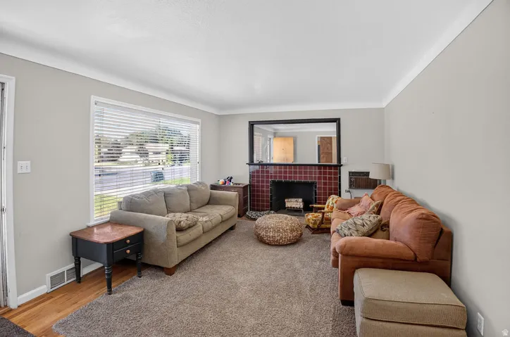 Living area featuring a tiled fireplace, large window, and light-toned walls