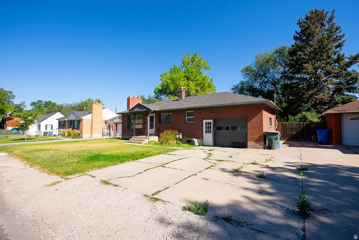 Brick exterior residence with a front porch, an attached garage, and a paved driveway