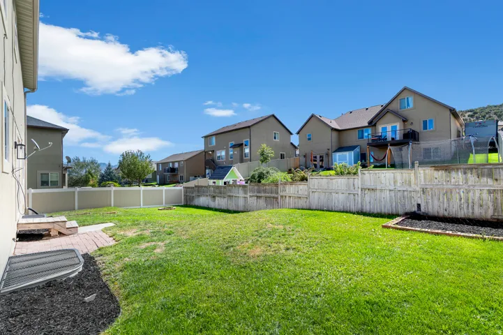 Expansive green lawn with a brick paver patio