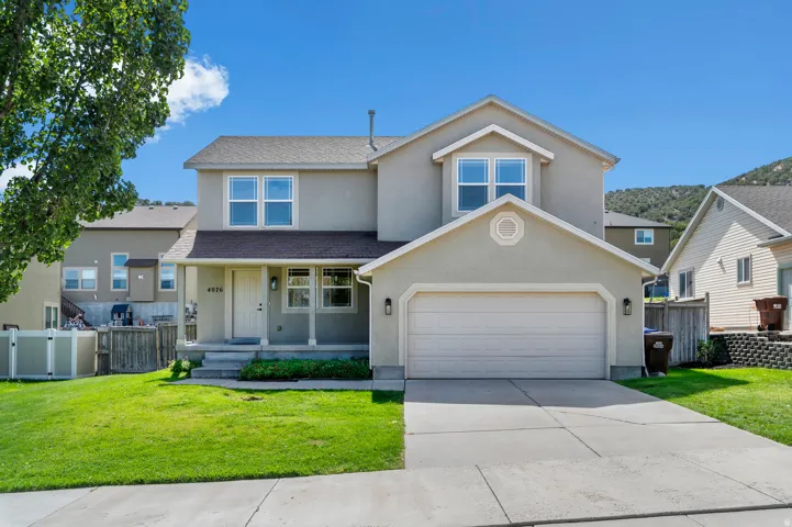Two-story stucco exterior with an attached two-car garage, covered porch, and concrete driveway