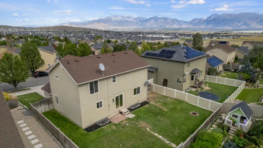 Expansive backyard featuring a manicured lawn, established landscaping, and a fenced perimeter
