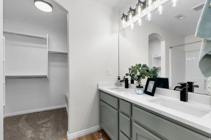 Dual vanity with integrated sinks, light-toned countertops, and matte black fixtures