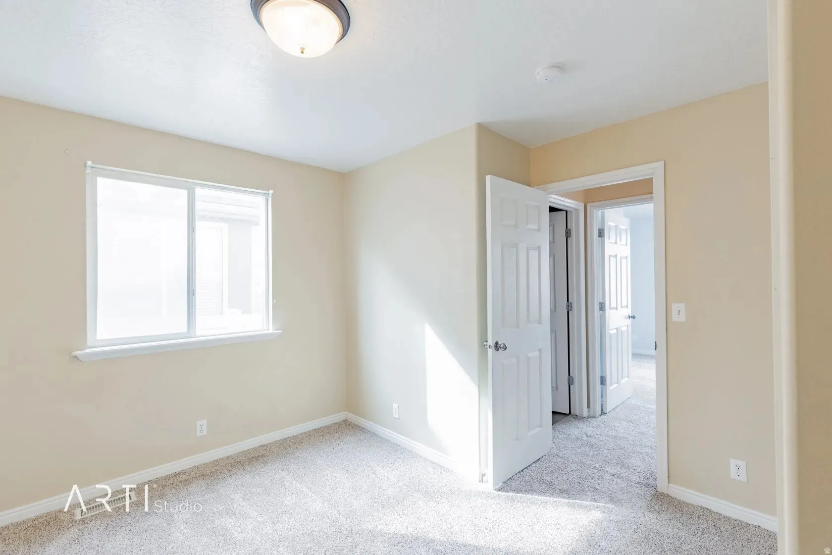 Neutral-toned walls complement the light-colored carpet flooring
