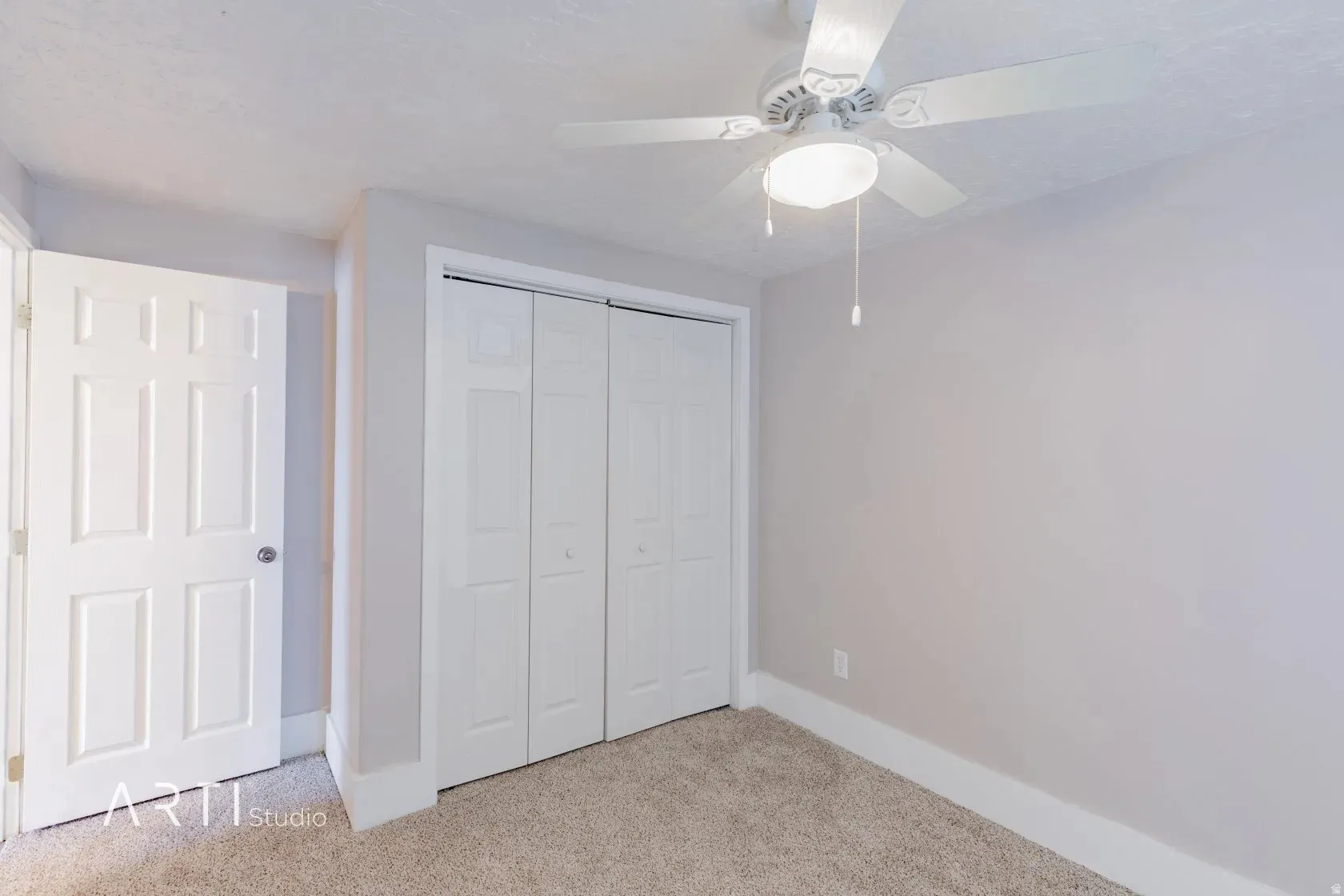 Neutral-toned walls complement the textured carpet flooring
