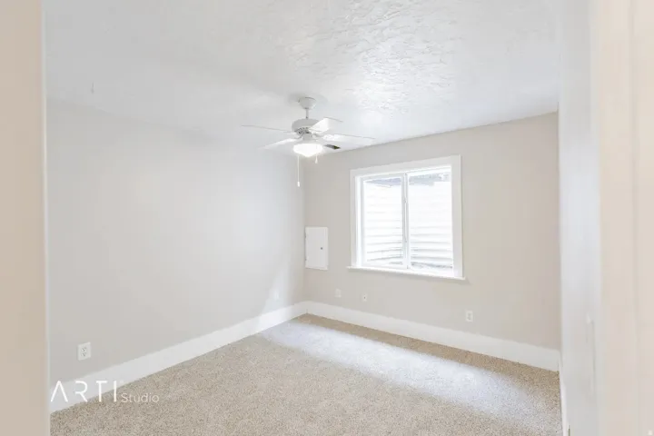 Recessed window with white trim, ceiling fan, and carpeted flooring
