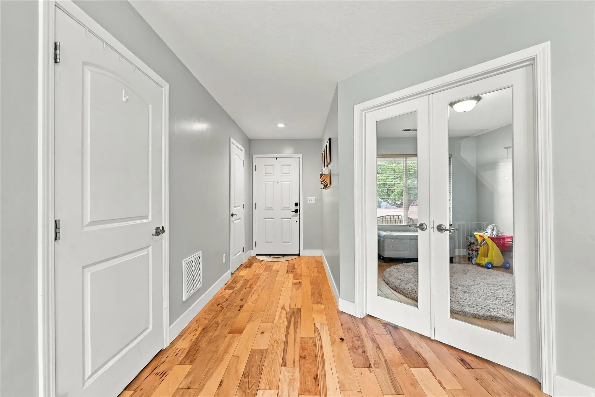 Hardwood flooring, painted walls, white trim, and white doors
