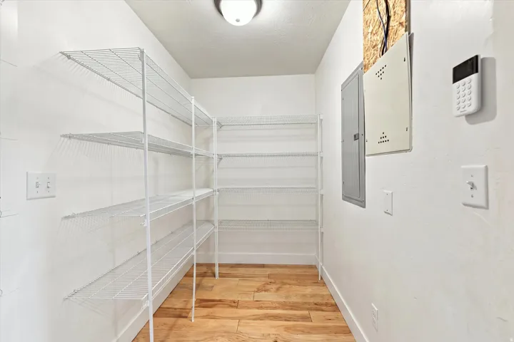 White wire shelving units, wood-finish flooring, and overhead lighting
