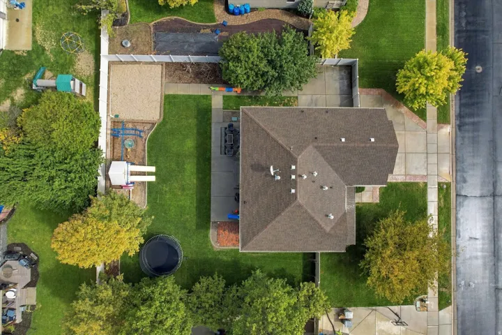 Expansive lot featuring a large lawn, mature trees, concrete patio, and fenced perimeter