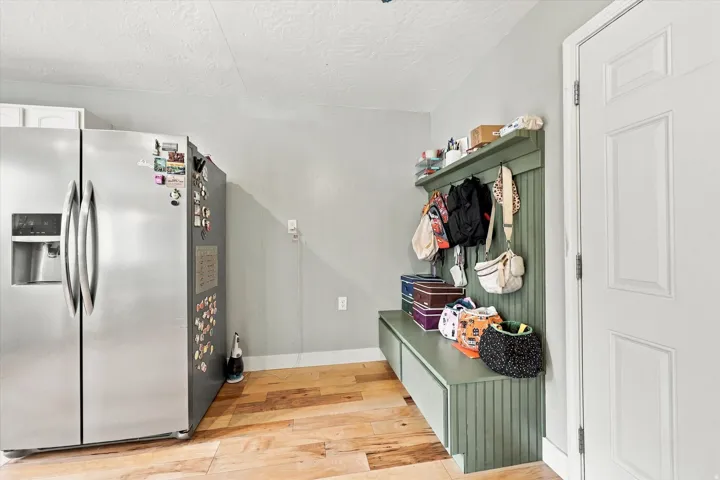 Wood-finish flooring, built-in storage bench, and a panel-style interior door