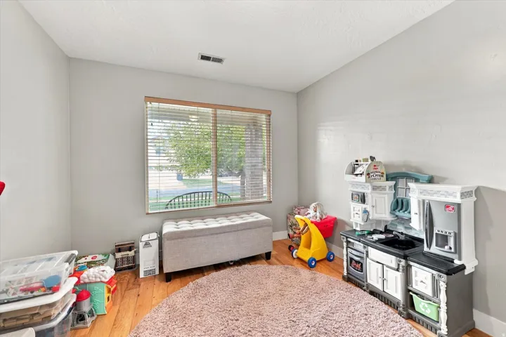 Recessed window with wood-finish blinds, light gray wall paint, and wood-finish flooring