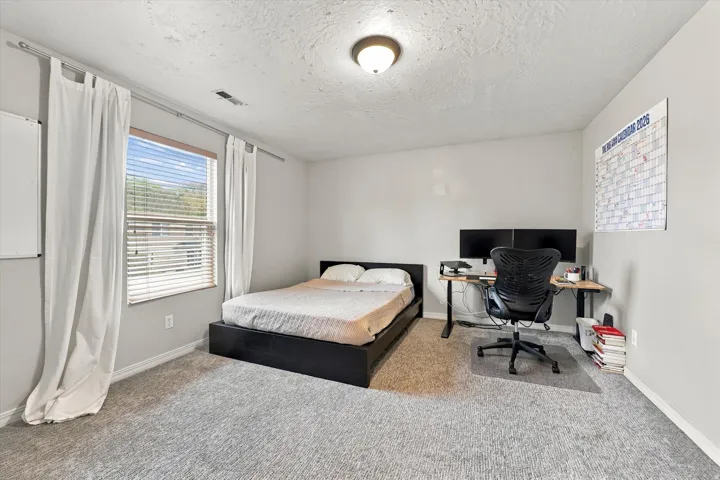 Neutral wall paint, textured ceiling, recessed lighting fixture, and carpet flooring