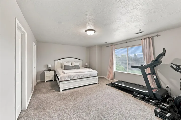 Spacious room featuring neutral carpeting and a large window with blinds