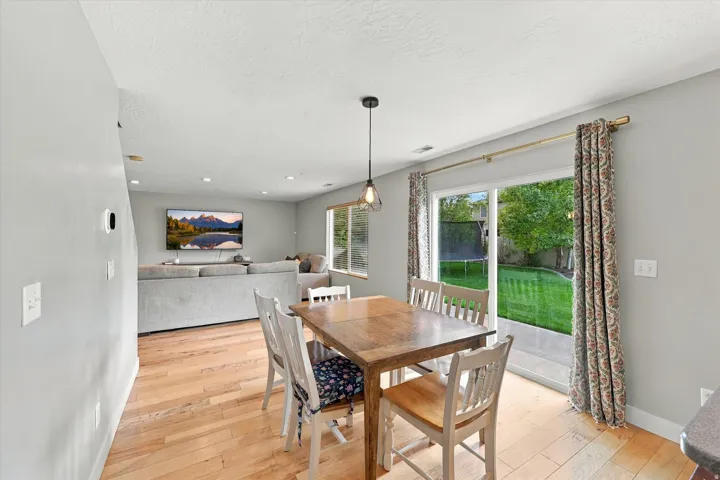 Hardwood-finish flooring, recessed ceiling lighting, sliding glass door, and backyard lawn