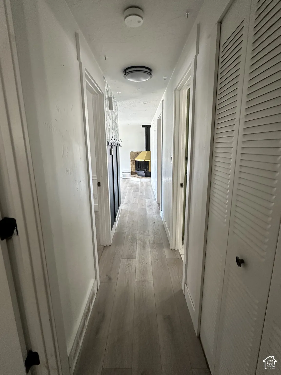 Wood-finish flooring throughout, bright overhead lighting, and louvered bifold closet doors