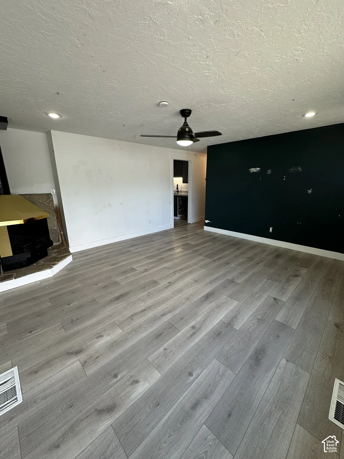 Wood-finish flooring, recessed lighting, ceiling fan, and a built-in fireplace with a hearth