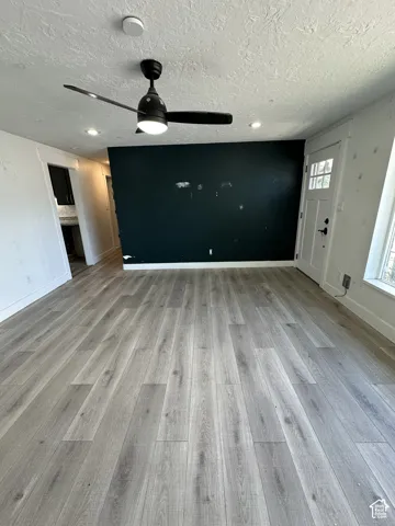 Wood-finish flooring throughout, complemented by a ceiling fan with integrated lighting and recessed lighting