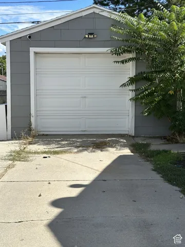 Attached garage featuring a panel-style door and gray siding