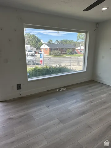 Wood-finish flooring with a wide window and white trim