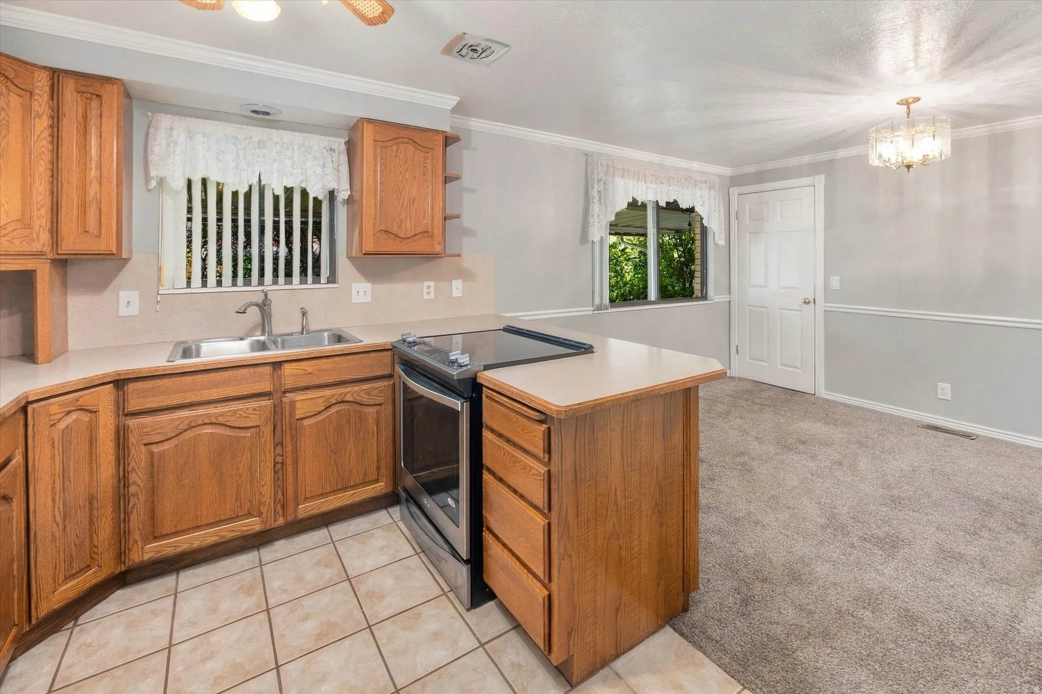 Kitchen featuring wood cabinetry, stainless steel range, and tile flooring