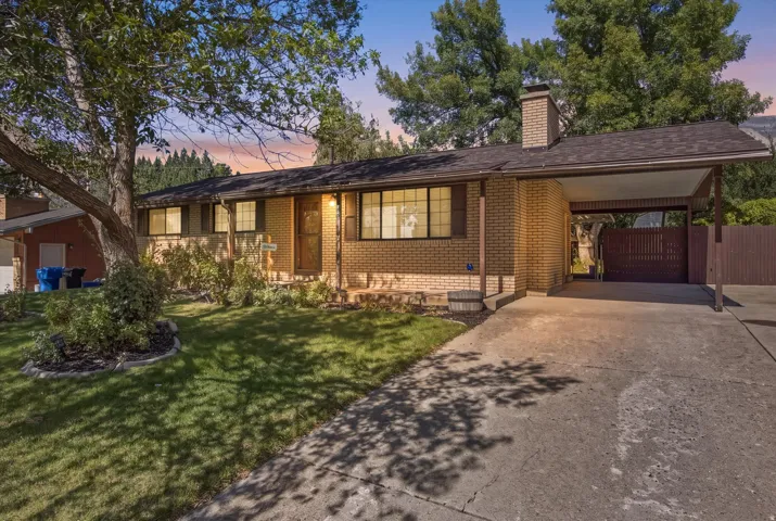 Brick exterior, established landscaping, attached carport, pitched roof, paved driveway
