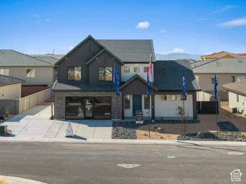 Contemporary two-story exterior with a mixed material facade featuring stone accents and vertical siding