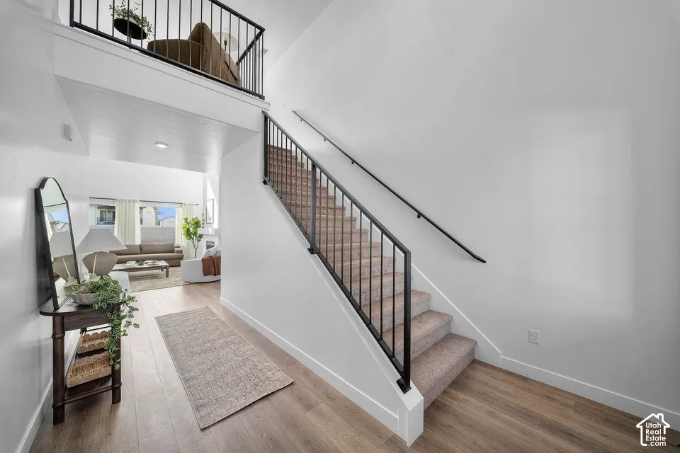 Staircase with black metal railings and neutral carpeting