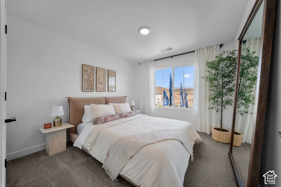 Recessed lighting, wall-to-wall carpeting, and a large window with white curtain rods and white drapes